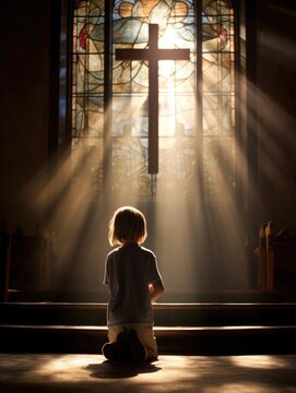 baby's first communion in church. a child prays near a stained glass window. faith Hope. kid folded his hands in prayer