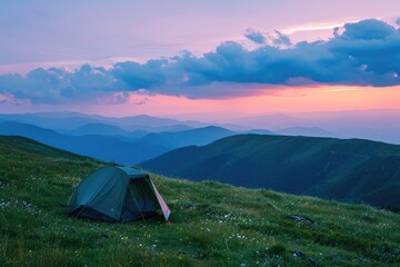 A tent is pitched high in a mountainous area during sunset