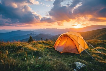 A tent is pitched high in a mountainous area during sunset