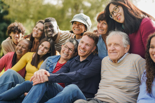 Group of multiracial people with different ages having fun together at city park - Community and social gathering concept