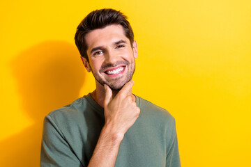 Photo of toothy beaming good mood man with bristle dressed khaki t-shirt keep arm on chin smiling...