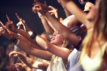 Night, concert and fans dance to music, performance and audience with energy at festival. Crowd, support and people stretching hands in celebration or praise of rock, culture or excited at event - obrazy, fototapety, plakaty