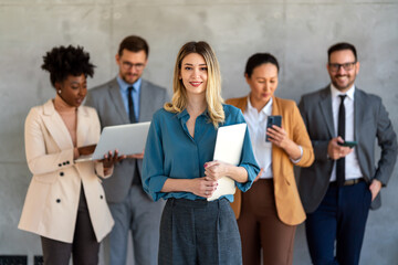 Portrait of multiethnic group of diverse corporate colleagues standing in a row at modern office