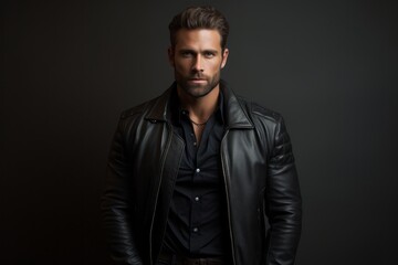 Obraz premium Portrait of a tender man in his 30s sporting a classic leather jacket against a modern minimalist interior. AI Generation