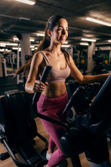 Obraz na płótnie Canvas A sportswoman exercising on ski machine in a gym.