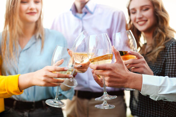Crop friends clinking glasses of wine