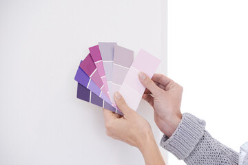 Hands, color swatches for interior design and paint choice, home renovation and person for...