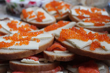 Sandwiches with red caviar and fish on bread. High quality stock photo of snacks.