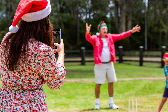 Christmastime family fun with mum photographing boys playing backyard cricket