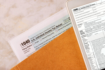Naklejka premium Filing online on digital tablet with individual income tax form 1040 is prepared by accounting office during tax season