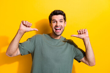 Photo of overjoyed optimistic man with bristle dressed khaki t-shirt indicating at himself isolated...