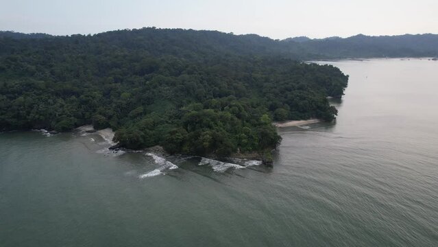 Aerial drone footage of clear, cloudy sky on the beach of Nusakambangan Island (also Nusakambangan or Nusa Kambangan Island) located in Cilacap Regency, Central Java, Indonesia