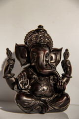 Black figurine of Lord Ganesh with white background, Indian Hindu God known as problem solver, obstacle remover
