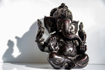 Black figurine of Lord Ganesh with white background, Indian Hindu God known as problem solver,...