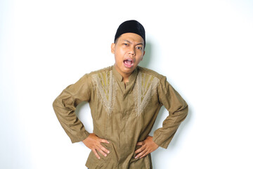 thoughtful asian muslim man wearing koko clothes confused with hand on waist isolated on white background