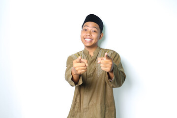 smiling asian muslim man wearing koko clothes pointing at camera with excitement isolated on white...