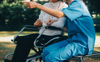 Fototapeta na wymiar A nurse take care a senior male on wheelchair in his garden at home