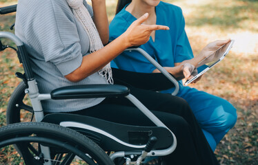 Elderly asian senior woman on wheelchair with Asian careful caregiver and encourage patient,...