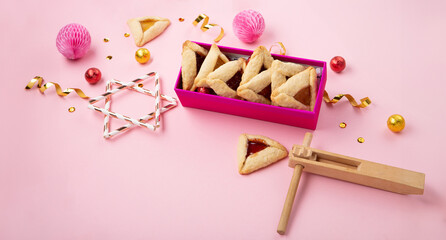 Purim Jewish Hamantaschen Cookies, Red Carnival Mask, Noisemaker on Pink Background. Purim Celebration, Jewish Carnival Holiday Concept.