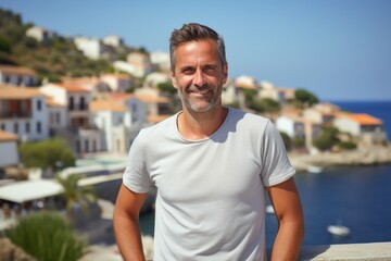 Fototapeta premium Portrait of a glad man in his 40s dressed in a casual t-shirt against a picturesque seaside village. AI Generation