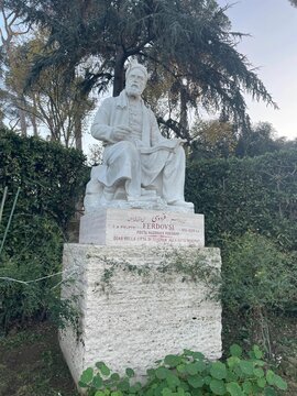 Ferdowsi statue of a person in a garden