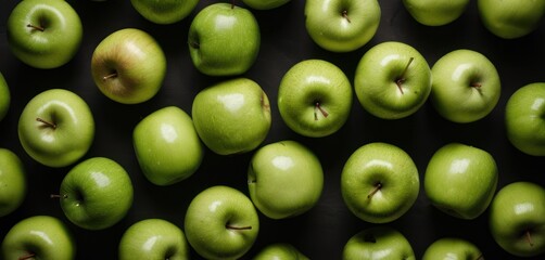  a group of green apples sitting next to each other on a black surface with one green apple in the middle of the photo and one green apple in the middle of the photo.