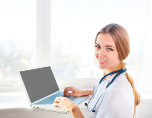 Portrait of young woman doctor at computer