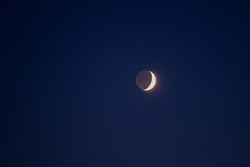 Natural satellite of the earth. Young crescent moon on a clear sky at the end of the day in the...