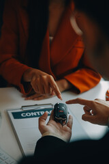 Closeup asian male people car salesman or sales manager offers to sell a car and explains and reads the terms of signing a car contract and insurance.