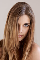 Fototapeta premium Portrait, straight hair and beauty of woman in salon treatment for keratin care. Serious face, hairstyle shine and young model in makeup cosmetics at hairdresser isolated on a gray studio background
