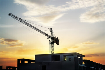 about the tower crane at a building when silhouette