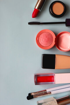 Various colorful make up products on bright blue background. Flat lay.
