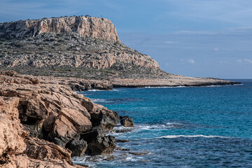 Fototapeta na wymiar View towards Cape Greco (in the east) of the dramatic Sea Caves, stunning rock formations on the south-eastern coastline of Cyprus, between the town of Ayia Napa and Cape Greco