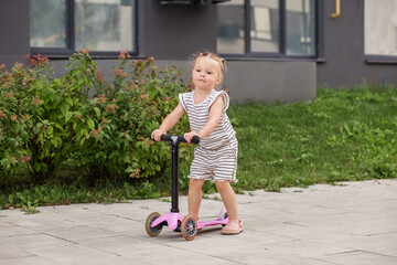 Toddler Girl Learning to Ride a Kick Scooter