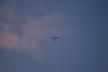 Fototapeta na wymiar Small plane flying in the blue sky. Single engine Cessna aircraft model