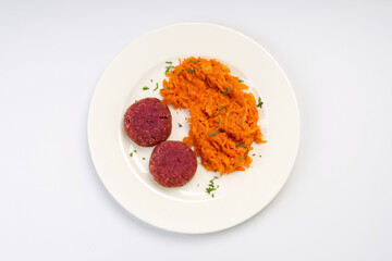 Business lunch. Vegetarian. Beetroot cutlets with stewed cabbage on a white plate and a white background.