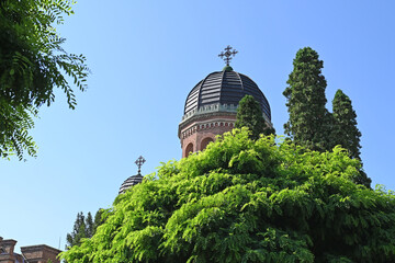 The dome of the orthodox monastery among green acacias.