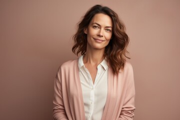 Fototapeta premium Portrait of a tender woman in her 40s wearing a chic cardigan against a pastel brown background. AI Generation