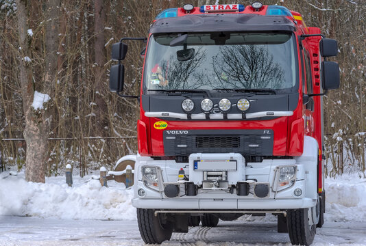 Polska Ćmielów 10 grudnia 2023 godz 11:48 . Bojowy wóz strażacki VOLVO zaparkowany wśród drzew w otoczeniu obficie spadłego puszystego białego śniegu.