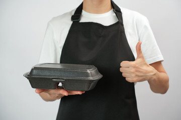 Chef holding lunch box with food in the hand, white background