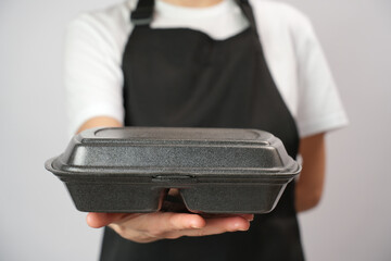 Chef holding lunch box with food in the hand, white background