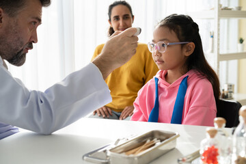 Mother with patient Asia daughter meeting caucasian doctor at hospital	