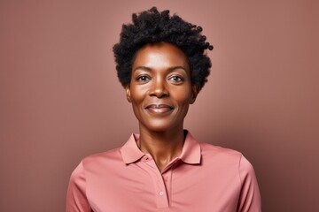 Obraz premium Portrait of a merry afro-american woman in her 40s wearing a sporty polo shirt against a soft brown background. AI Generation