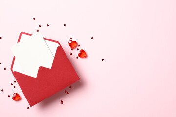 Red paper envelope with blank white note mockup inside and hearts on pink background. Romantic...