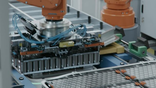 EV Battery Pack for Automotive Industry Assembly. Robot Arm Installing Battery Module into the Frame. Electric Car Smart Factory. Battery Manufacturing Line. Automated Production Line.