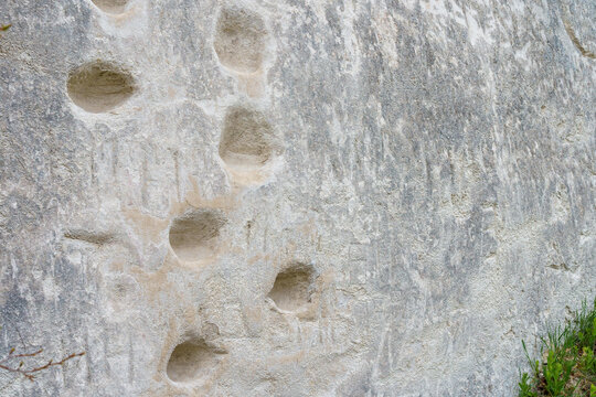 Foot recesses for climbing in limestone rock. Background with selective focus and copy space - Powered by Adobe