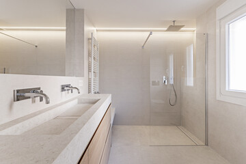 Fototapeta na wymiar Modern design bathroom with oak wood furniture, stone sink on a drawer unit and shower cabin in the background