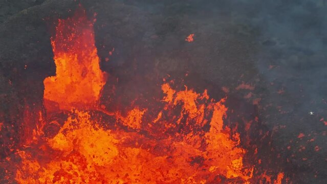 Aerial drone fly view over active volcanic crater eruption. Hot lava and magma coming out of the crater. Tourist attraction in Iceland Litli-Hr&uacute;tur eruption 2023. Beautiful and dangerous disaster.