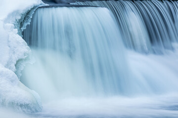Winter, Rabbit River Cascade framed by ice and captured with motion blur, Michigan, USA