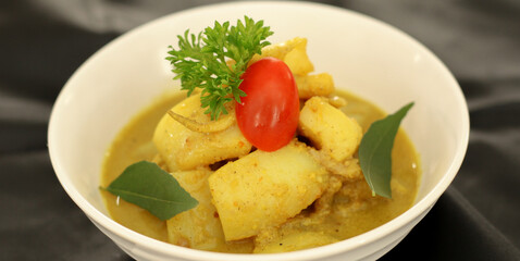 Gulai Cumi or Squid cooked yellow seasoning with coconut milk. Specialties Padang, West Sumatra Indonesia. Selective focus.
